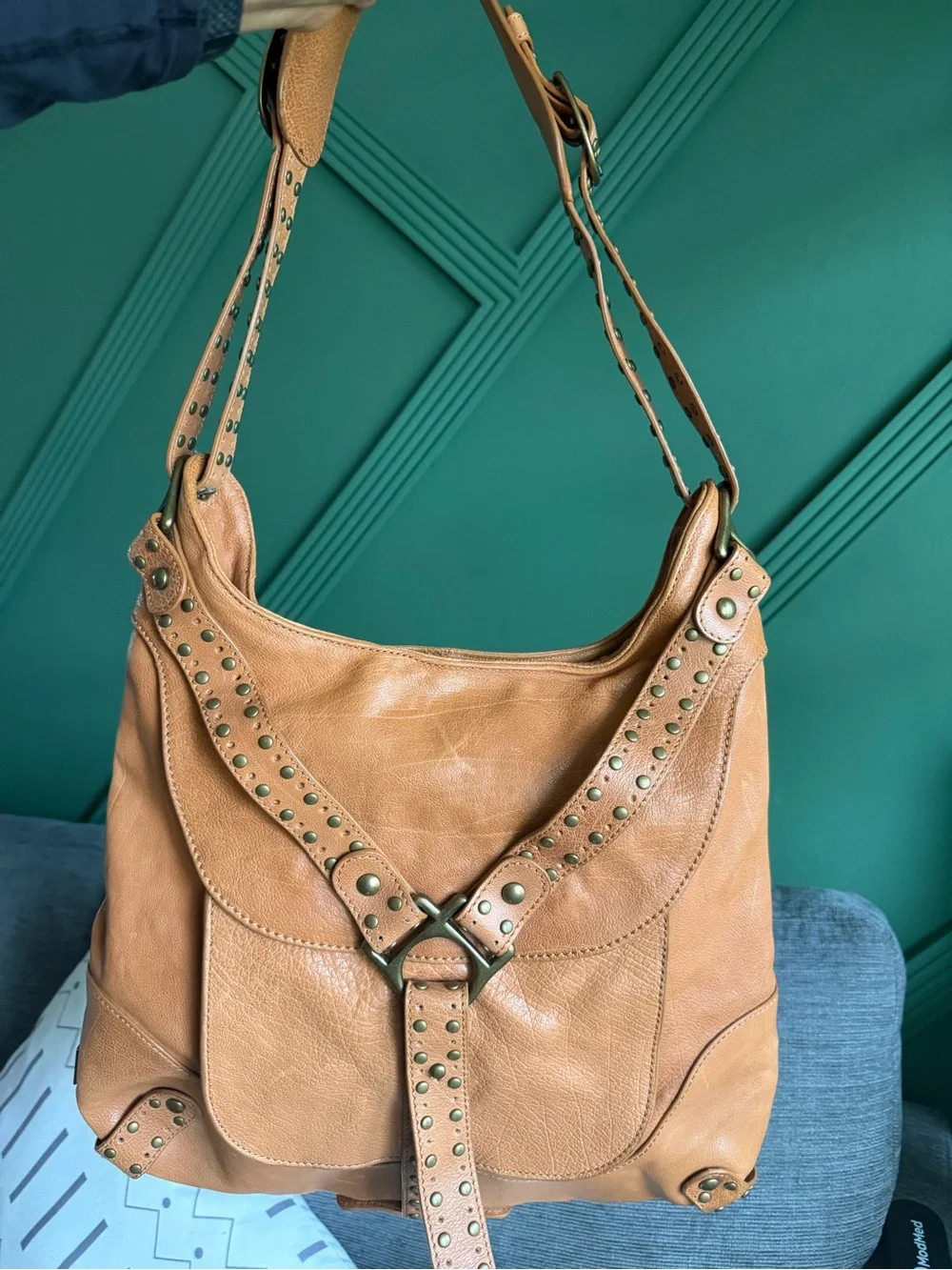 Kooba Hobo Bag features distinctive gold-tone hardware and stud detailing.